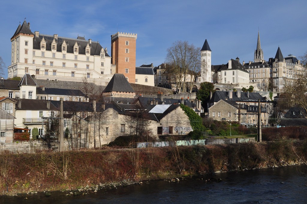 Vue de Pau, France, avec le château de Pau et un mélange de bâtiments résidentiels contre un ciel bleu clair, avec une rivière au premier plan. Vue de Pau, France, avec le château de Pau et un mélange de bâtiments résidentiels contre un ciel bleu clair, avec une rivière au premier plan.